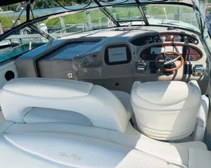 Slide: The Image of The image shows the cockpit of a 1999 Sea Ray 410 Express Cruiser with white leather seating. - 17