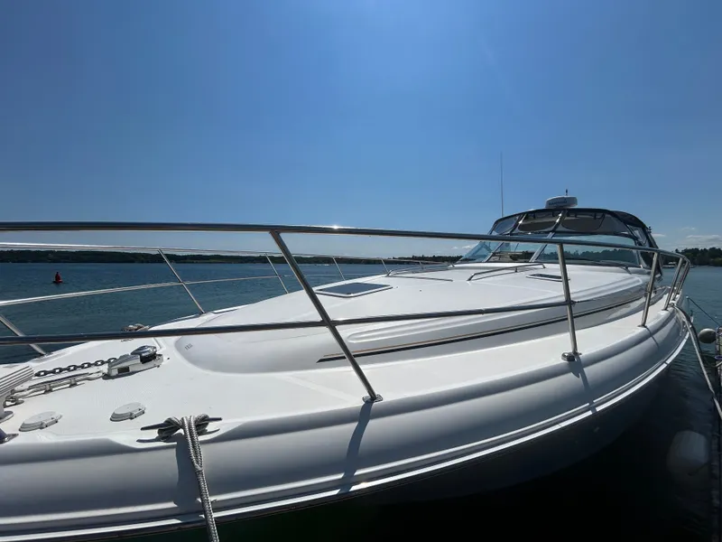 The Image of A 1999 Sea Ray 410 Express Cruiser on the water, featuring a sleek white deck and stainless steel railings. - 23