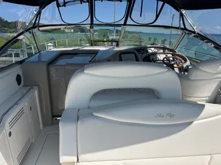 Slide: The Image of Interior of a 1999 Sea Ray 410 Express Cruiser with white upholstery and a view of the water. - 15