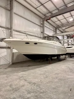 Slide: The Image of A 1999 Sea Ray 410 Express Cruiser is propped up in a warehouse. - 0