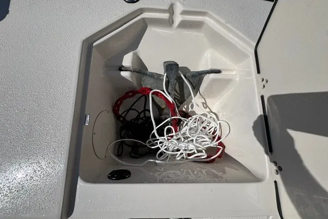 Slide: The Image of Anchor storage compartment on a 2021 Carolina Skiff 19 LS boat, featuring ropes and anchor. - 17