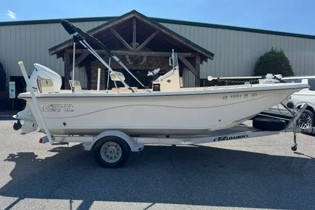 The Image of 2021 Carolina Skiff 19 LS boat on trailer, parked outside a building. - 1