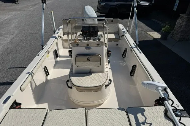Slide: The Image of 2021 Carolina Skiff 19 LS boat interior with seating and console, parked outdoors. - 8