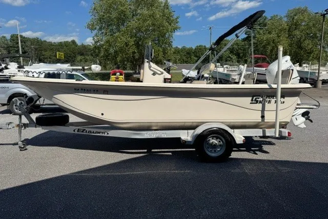Slide: The Image of 2021 Carolina Skiff 19 LS boat on trailer, parked outdoors under clear blue sky. - 4