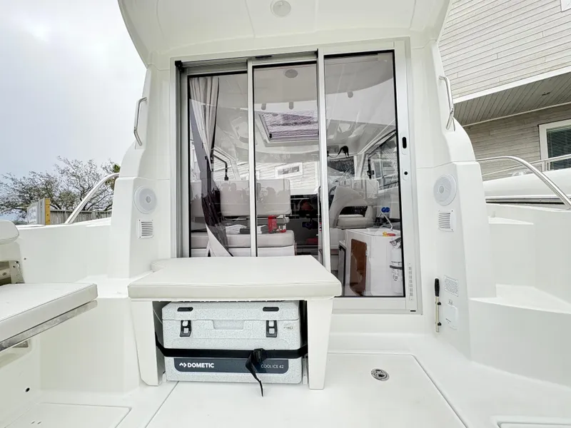 Slide: The Image of 2024 Beneteau Antares 8 boat interior with sliding glass door and seating area. - 6