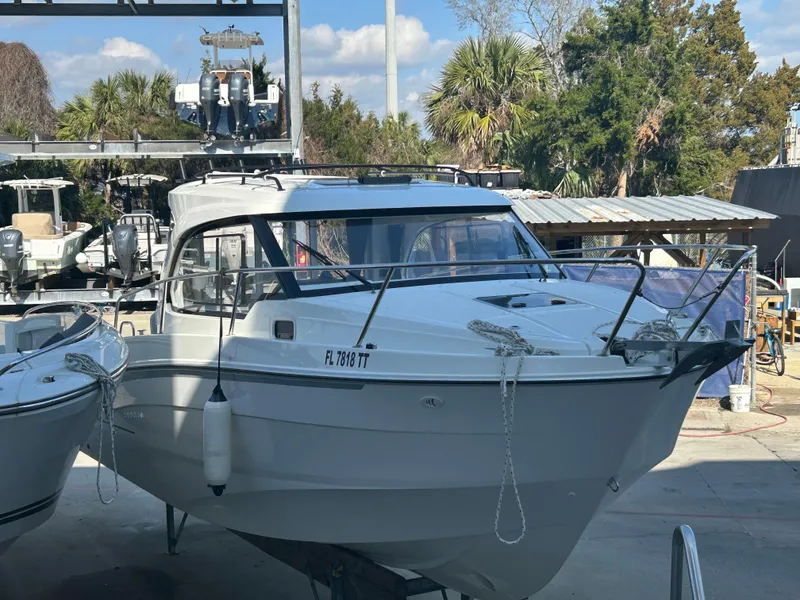 Slide: The Image of 2024 Beneteau Antares 8 boat docked outdoors, surrounded by trees and other vessels. - 4