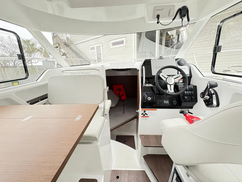 Slide: The Image of 2024 Beneteau Antares 8 interior with modern helm and seating area. - 10