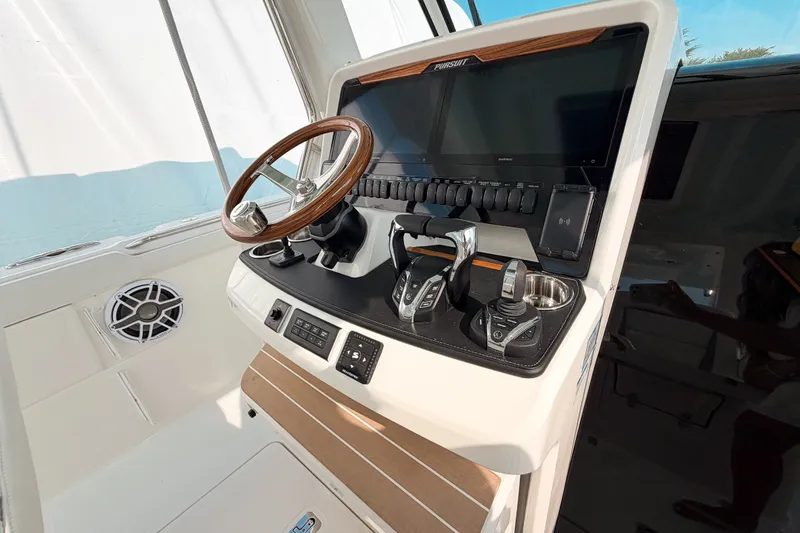 Slide: The Image of 2027 Pursuit S 328 Sport boat dashboard with steering wheel and controls. - 16