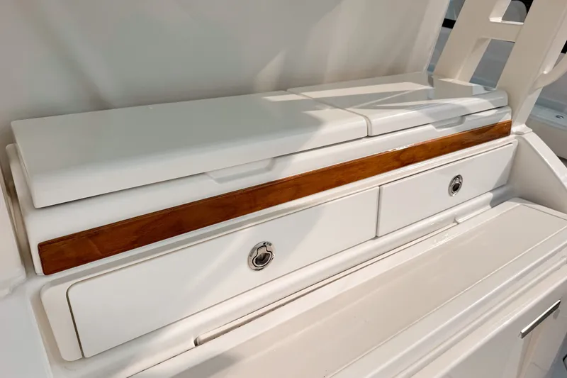 Slide: The Image of 2027 Pursuit S 328 Sport boat interior with sleek white cabinetry and wood accents. - 8