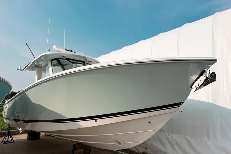 The Image of 2027 Pursuit S 328 Sport boat with sleek design, docked under clear blue sky. - 0