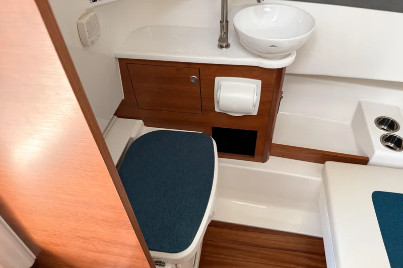 Slide: The Image of 2026 Pursuit S 328 Sport boat bathroom with wooden cabinetry and modern fixtures. - 24