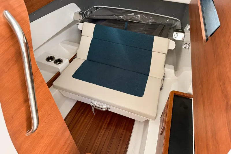 Slide: The Image of 2026 Pursuit S 328 Sport cabin interior with cushioned seating and wooden accents. - 23