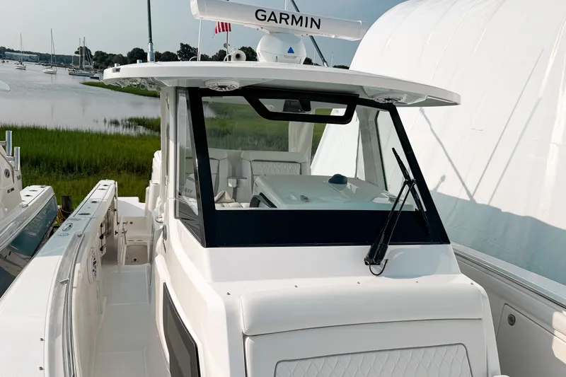 Slide: The Image of 2027 Pursuit S 328 Sport boat docked near a serene waterfront. - 18