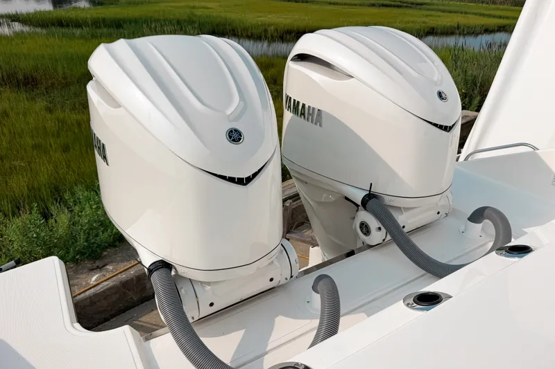 Slide: The Image of Twin Yamaha outboard engines on a 2027 Pursuit S 328 Sport boat, docked near lush greenery. - 3