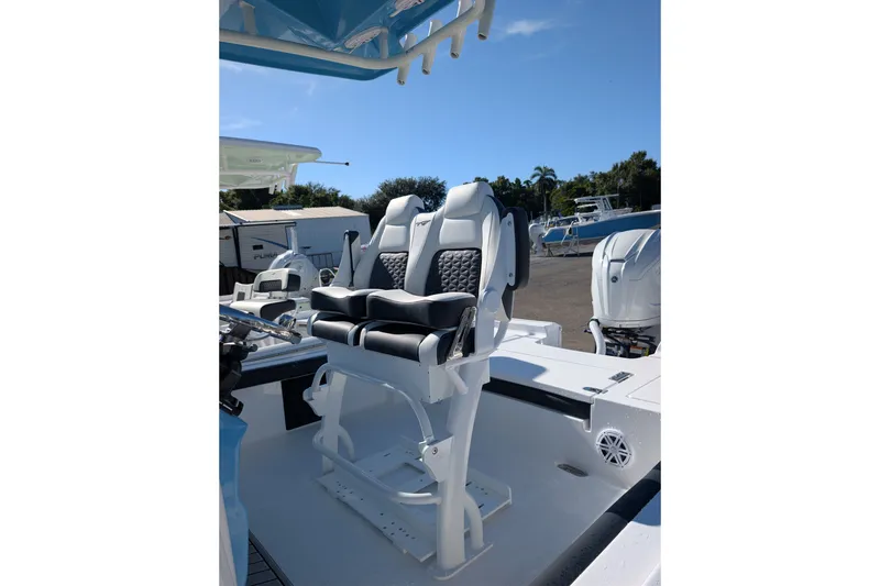 Slide: The Image of 2027 Tidewater 2500 Carolina Bay boat with dual captain's chairs under blue sky. - 4