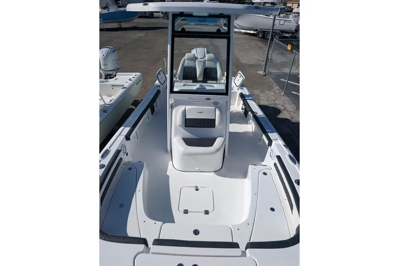 Slide: The Image of 2027 Tidewater 2500 Carolina Bay boat interior with seating and console, docked outdoors. - 12