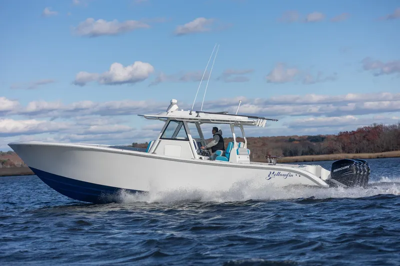 Slide: The Image of 2018 Yellowfin 39 Offshore boat cruising on a lake under a partly cloudy sky. - 49