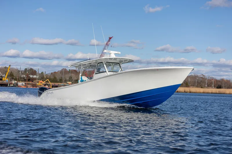 Slide: The Image of 2018 Yellowfin 39 Offshore boat cruising on a sunny day, blue and white design. - 21