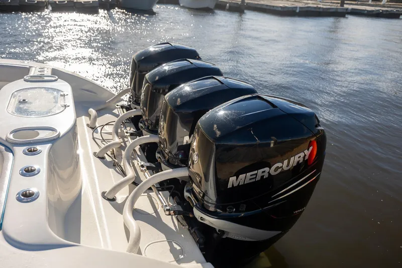 Slide: The Image of 2018 Yellowfin 39 Offshore boat with four Mercury outboard engines docked by the water. - 14