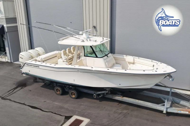 The Image of 2024 Grady-White Canyon 336 boat on trailer, featuring triple engines, parked outdoors. - 0