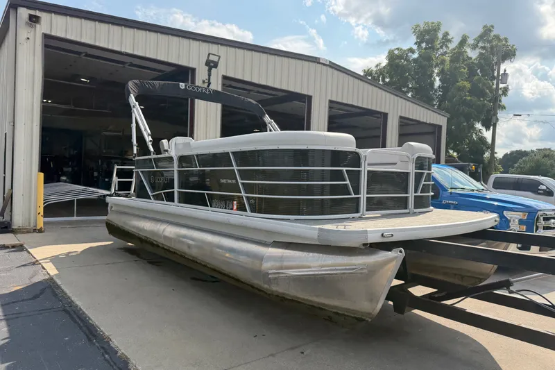 The Image of 2023 Godfrey Sweetwater 2086 CX pontoon boat outside a garage on a sunny day. - 1