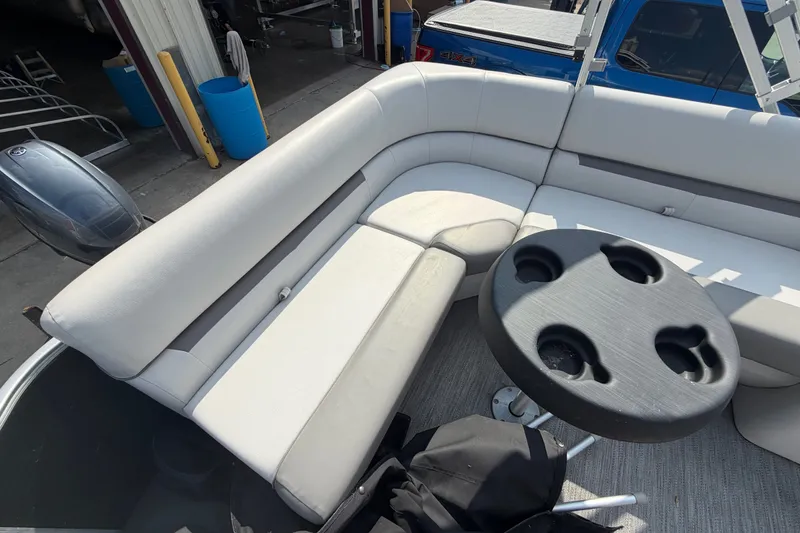 Slide: The Image of 2023 Godfrey Sweetwater 2086 CX pontoon boat interior with cushioned seating and cup holder table. - 16