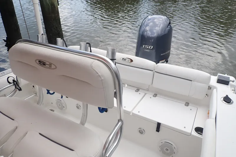 Slide: The Image of 2017 Sea Hunt Ultra 211 boat interior with Yamaha 150 engine on calm water. - 20