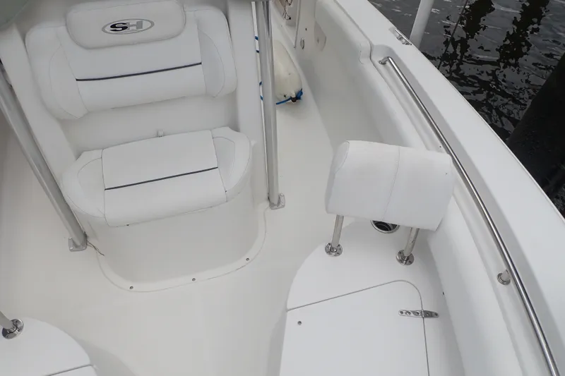 Slide: The Image of 2017 Sea Hunt Ultra 211 boat interior with white cushioned seating and stainless steel fixtures. - 13