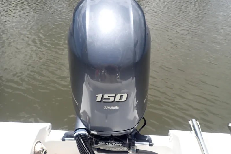 Slide: The Image of Yamaha 150 outboard motor on 2017 Sea Hunt Ultra 211 boat, docked on calm water. - 6