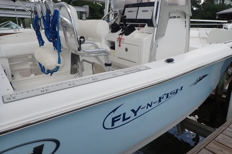 Slide: The Image of 2017 Sea Hunt Ultra 211 boat with "Fly-N-Fish" decal, docked and equipped with fishing gear. - 36