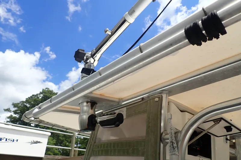 Slide: The Image of 2017 Sea Hunt Ultra 211 boat with T-top and rod holders under a blue sky. - 28
