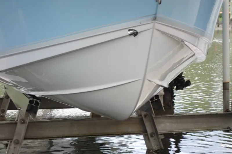 Slide: The Image of 2017 Sea Hunt Ultra 211 boat hull on lift, partially submerged in water. - 49