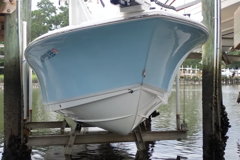 Slide: The Image of 2017 Sea Hunt Ultra 211 boat on lift, docked by water. - 2