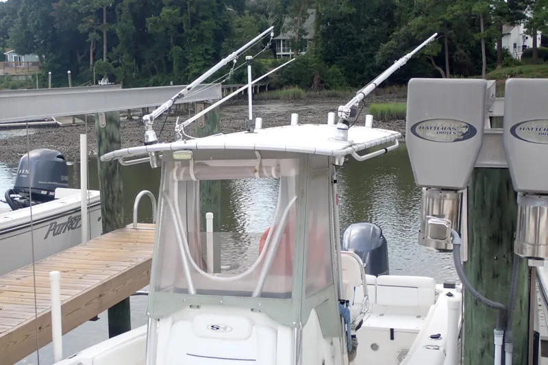 Slide: The Image of 2017 Sea Hunt Ultra 211 boat docked with fishing rods and outboard motor. - 7