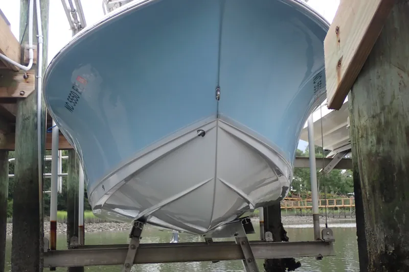 Slide: The Image of 2017 Sea Hunt Ultra 211 boat on lift, showcasing sleek blue hull design. - 48