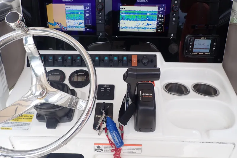 Slide: The Image of 2017 Sea Hunt Ultra 211 boat dashboard with steering wheel, Yamaha controls, and Simrad displays. - 21