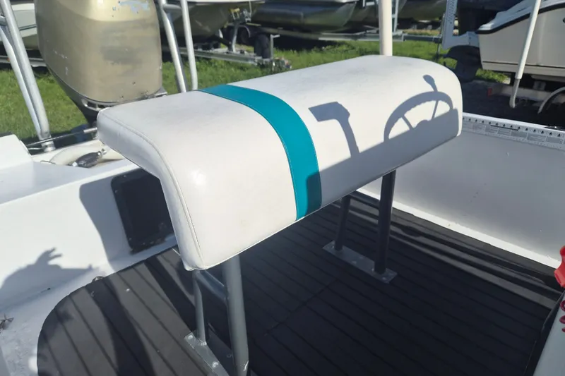 Slide: The Image of 1992 Key West 1720 Center Console boat seat with teal stripe and steering wheel shadow. - 6