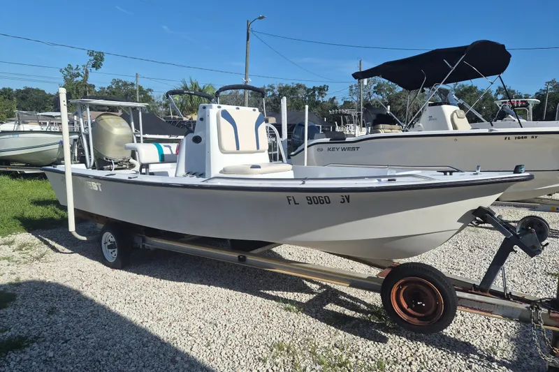 The Image of 1992 Key West 1720 Center Console boat on trailer, parked outdoors under clear blue sky. - 1