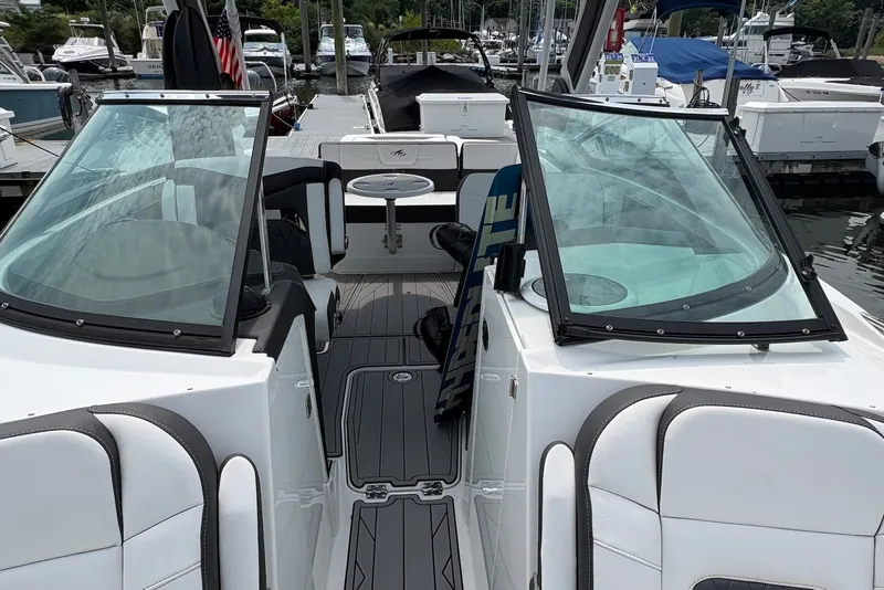 Slide: The Image of 2023 Monterey 298SS Super Sport boat interior with seating and windshield at marina. - 22
