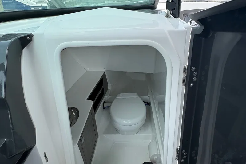 Slide: The Image of 2023 Monterey 298SS Super Sport boat interior with compact marine toilet. - 23