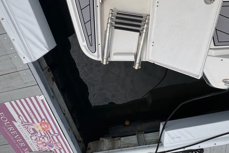Slide: The Image of 2023 Monterey 298SS Super Sport boat docked, featuring swim platform and ladder. - 25