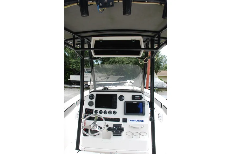 Slide: The Image of 2014 Scarab 255 boat dashboard with steering wheel and navigation equipment. - 15