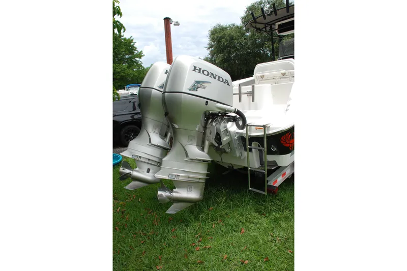 Slide: The Image of 2014 Scarab 255 boat with dual Honda outboard motors on grassy area. - 22