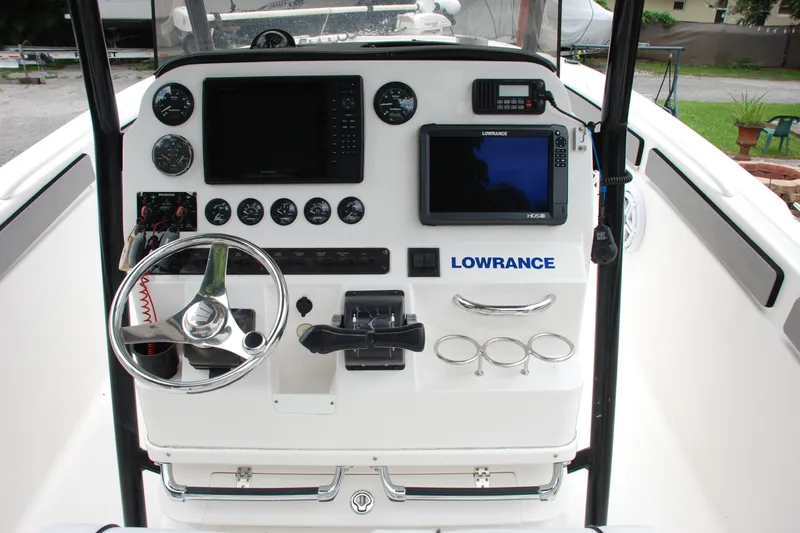Slide: The Image of Control panel of a 2014 Scarab 255 boat featuring navigation and steering equipment. - 16