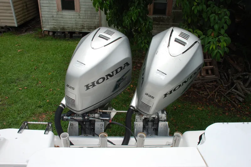 Slide: The Image of Twin Honda 225 outboard motors on a 2014 Scarab 255 boat, parked on grass. - 20