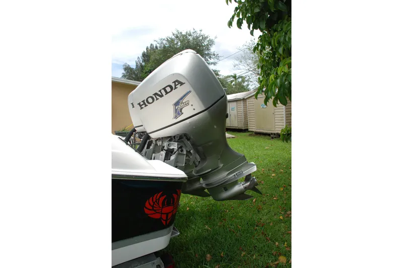 Slide: The Image of Honda outboard motor on 2014 Scarab 255 boat, parked on grass. - 24