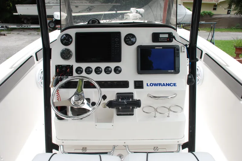 Slide: The Image of 2014 Scarab 255 boat dashboard with steering wheel, gauges, and Lowrance navigation system. - 19