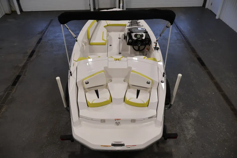 Slide: The Image of 2017 Scarab 165 G boat, top view, white with green accents, in a garage setting. - 10