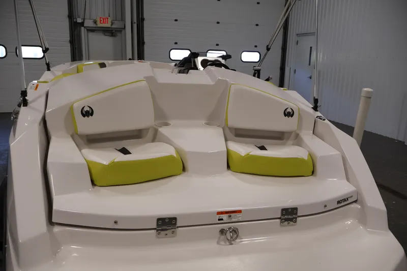 Slide: The Image of 2017 Scarab 165 G boat interior with white and lime green seating in a garage. - 28