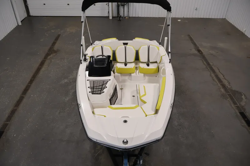Slide: The Image of 2017 Scarab 165 G boat with yellow-accented seating in a garage setting. - 9
